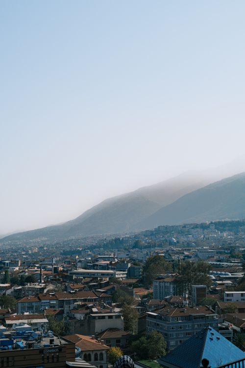 Free A panoramic view of a city with a stunning mountain backdrop captured during daylight. Stock Photo