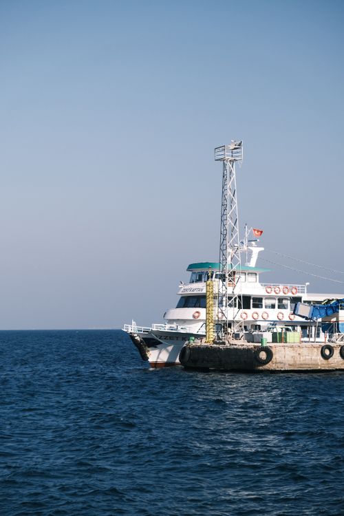 Free A ship anchored at a harbor on a calm sea under a clear blue sky. Stock Photo