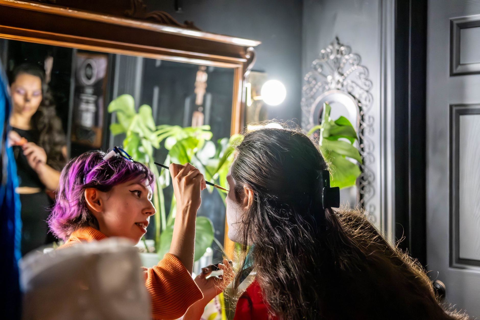 Artistic makeup application scene captured indoors with vibrant expressions in Toronto.