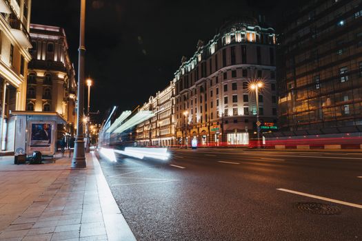 Long exposure of a bustling city street at night capturing vibrant light trails.