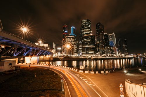 Free Stunning nighttime cityscape featuring illuminated skyscrapers and a bridge with glowing streetlights. Stock Photo