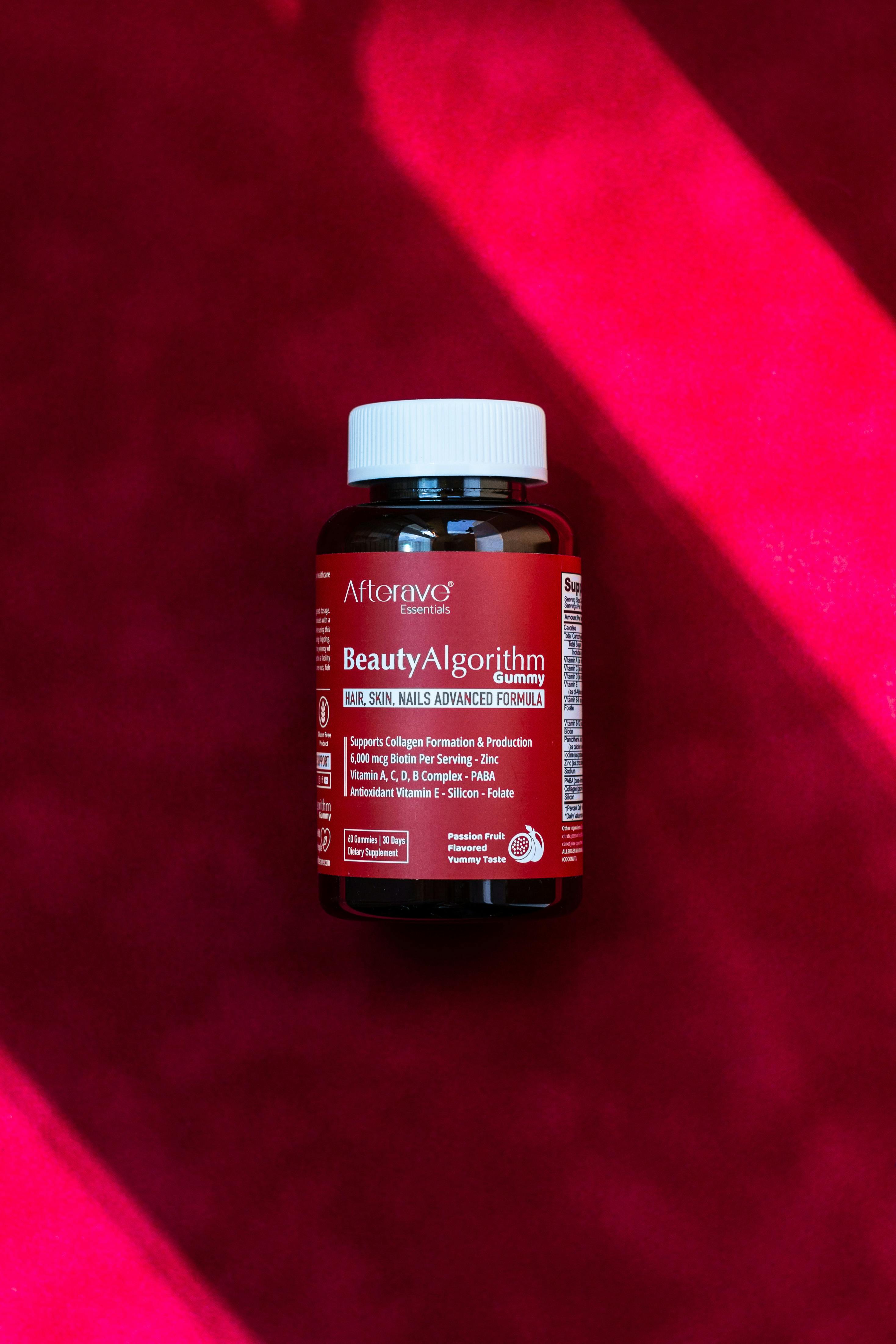 Afterave Beauty Algorithm hair skin nails gummies resting on vibrant red surface.