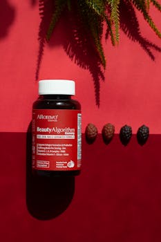 Biotin supplement bottle against a red backdrop with shadows.