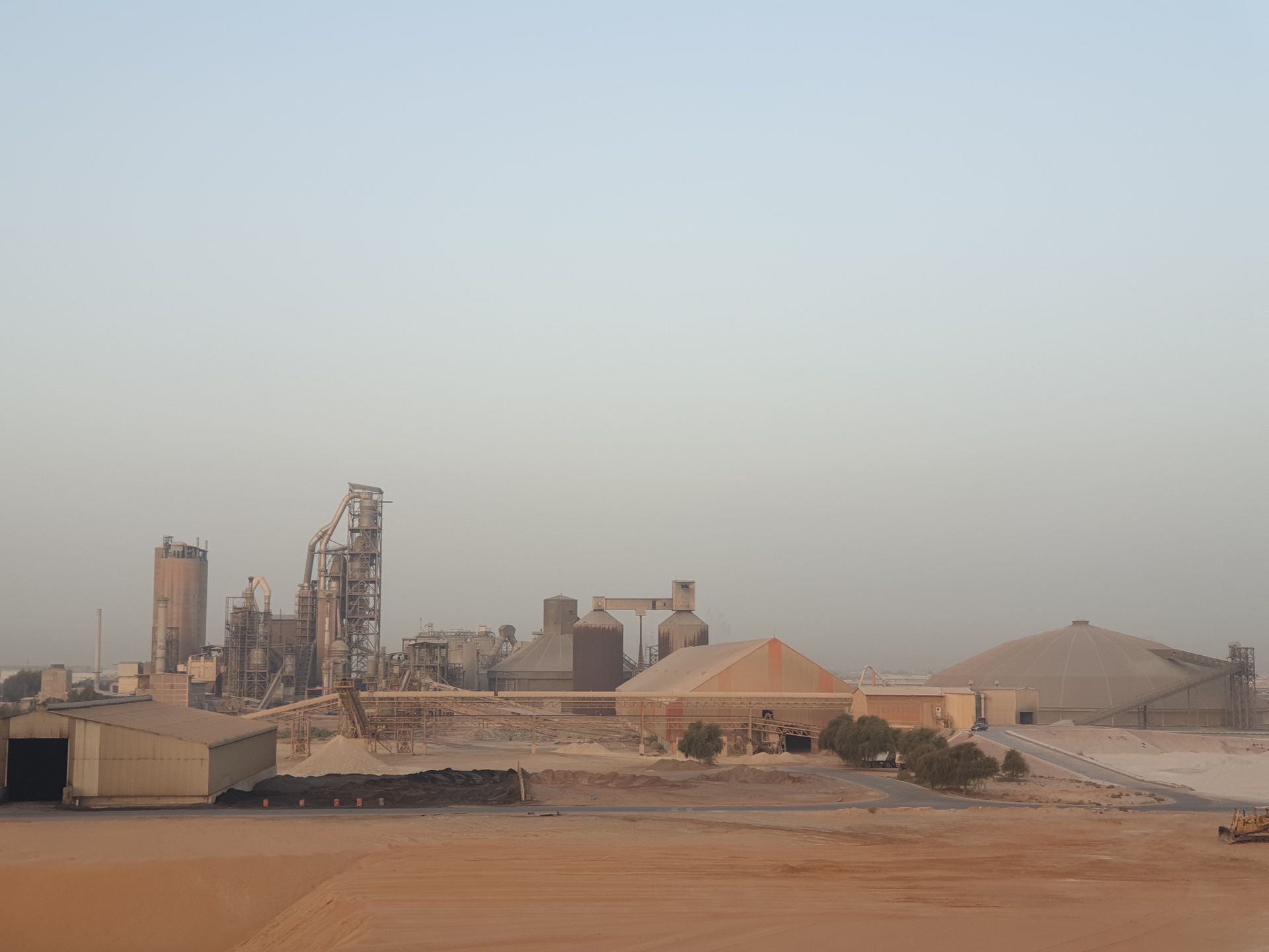 A vast industrial complex set in a desert environment under a clear sky.