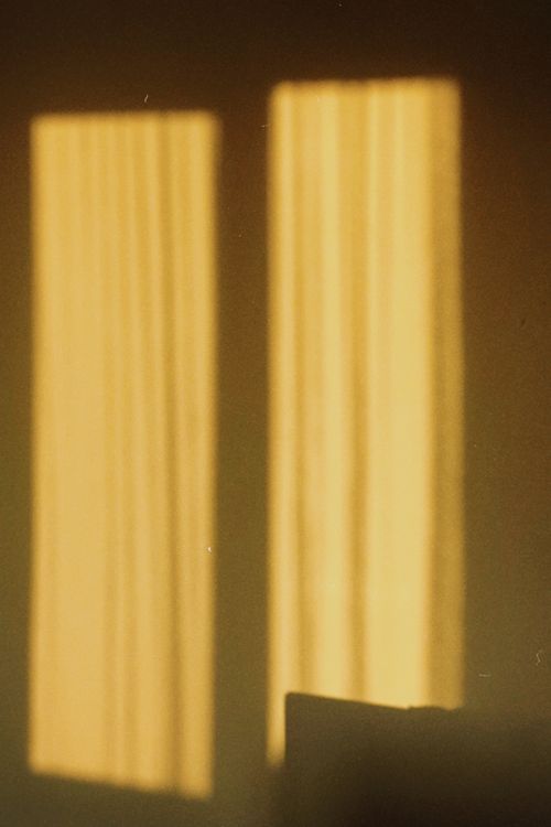 Free Artistic shadow of window on a wall creating a warm glow indoors at sunset. Stock Photo