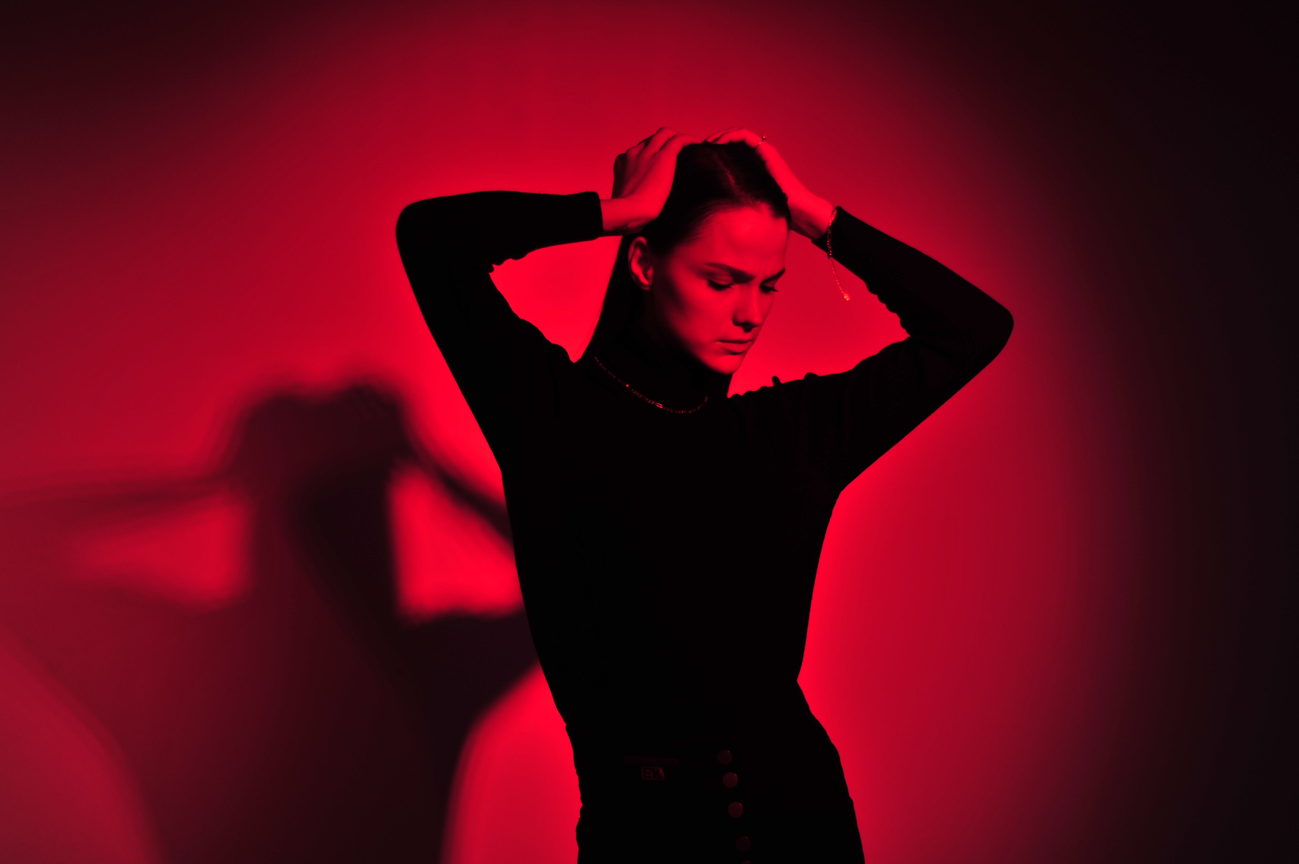 Artistic portrait of a young woman in dramatic red lighting.
