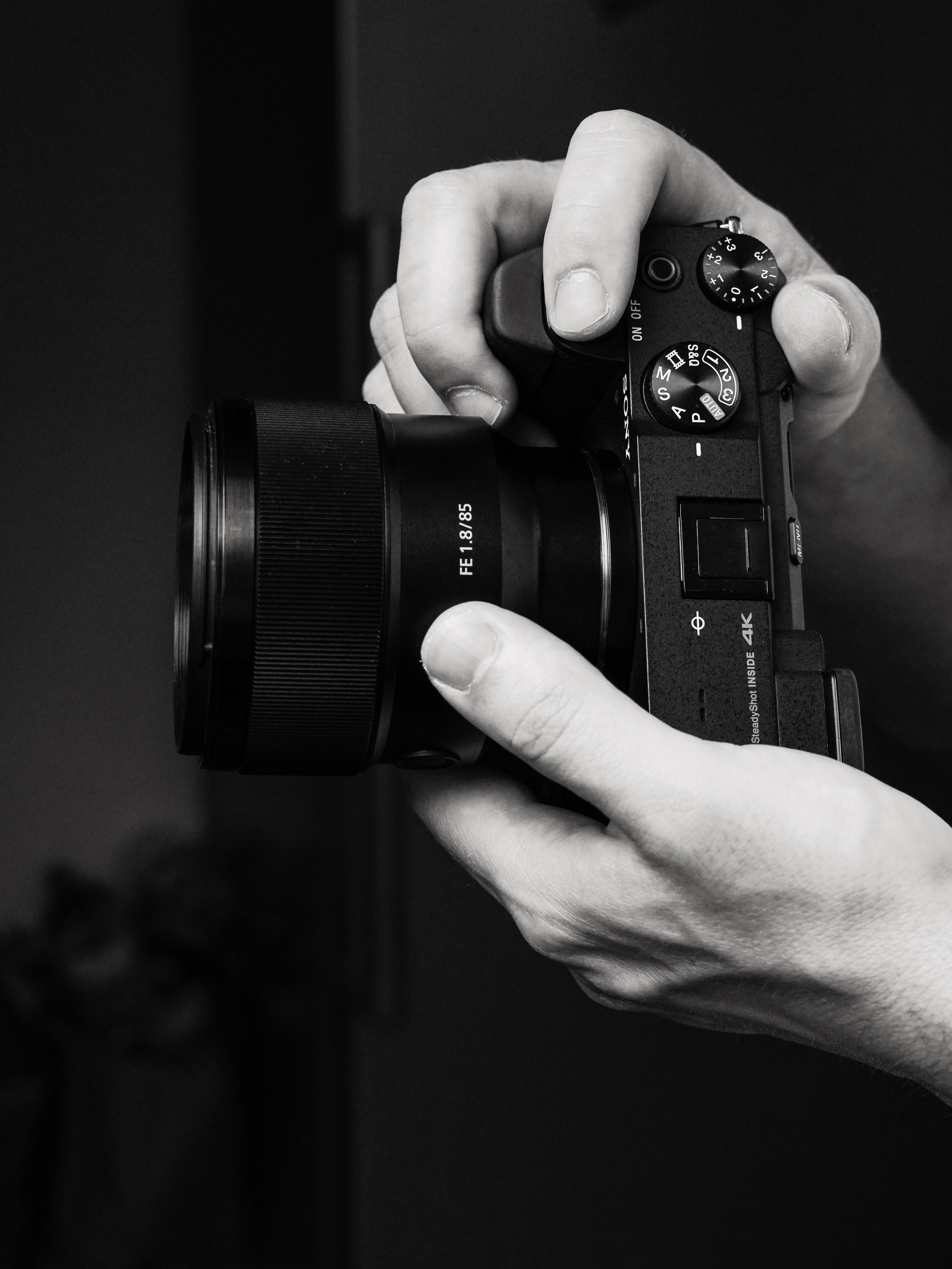Hands Holding a Digital Mirrorless Camera Close-Up · Free Stock Photo