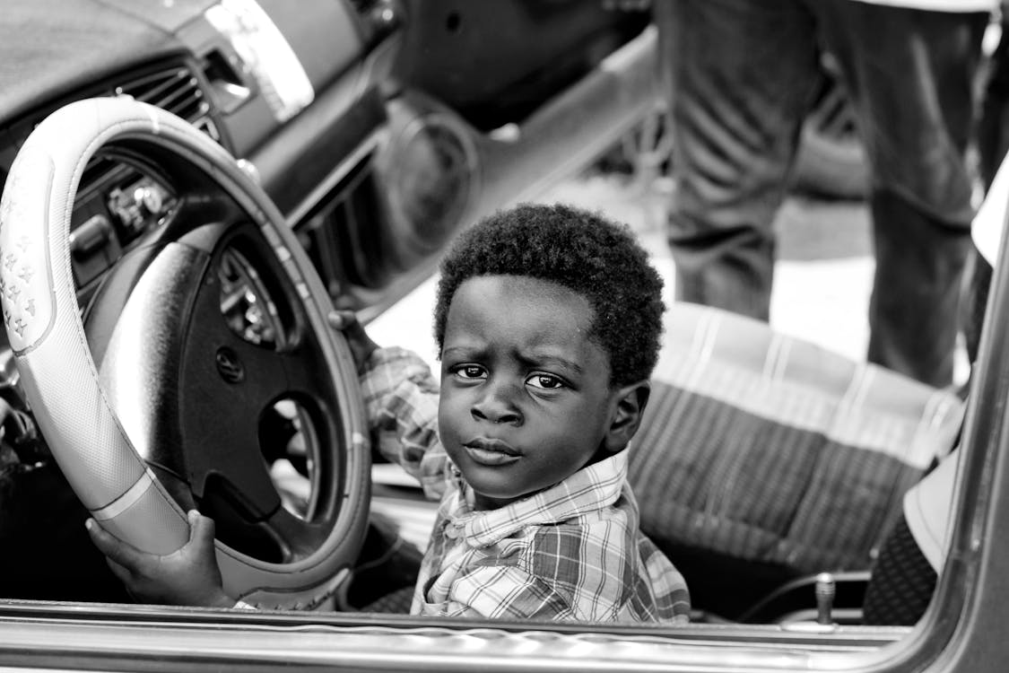 Free Grayscale Photo of Boy Riding Car Stock Photo