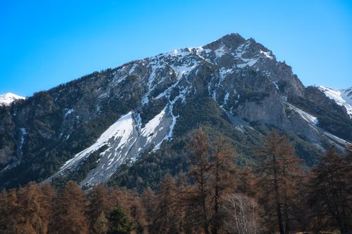 Free A stunning view of snow-capped mountains in Reschen am See, Italy under a clear blue sky. Stock Photo