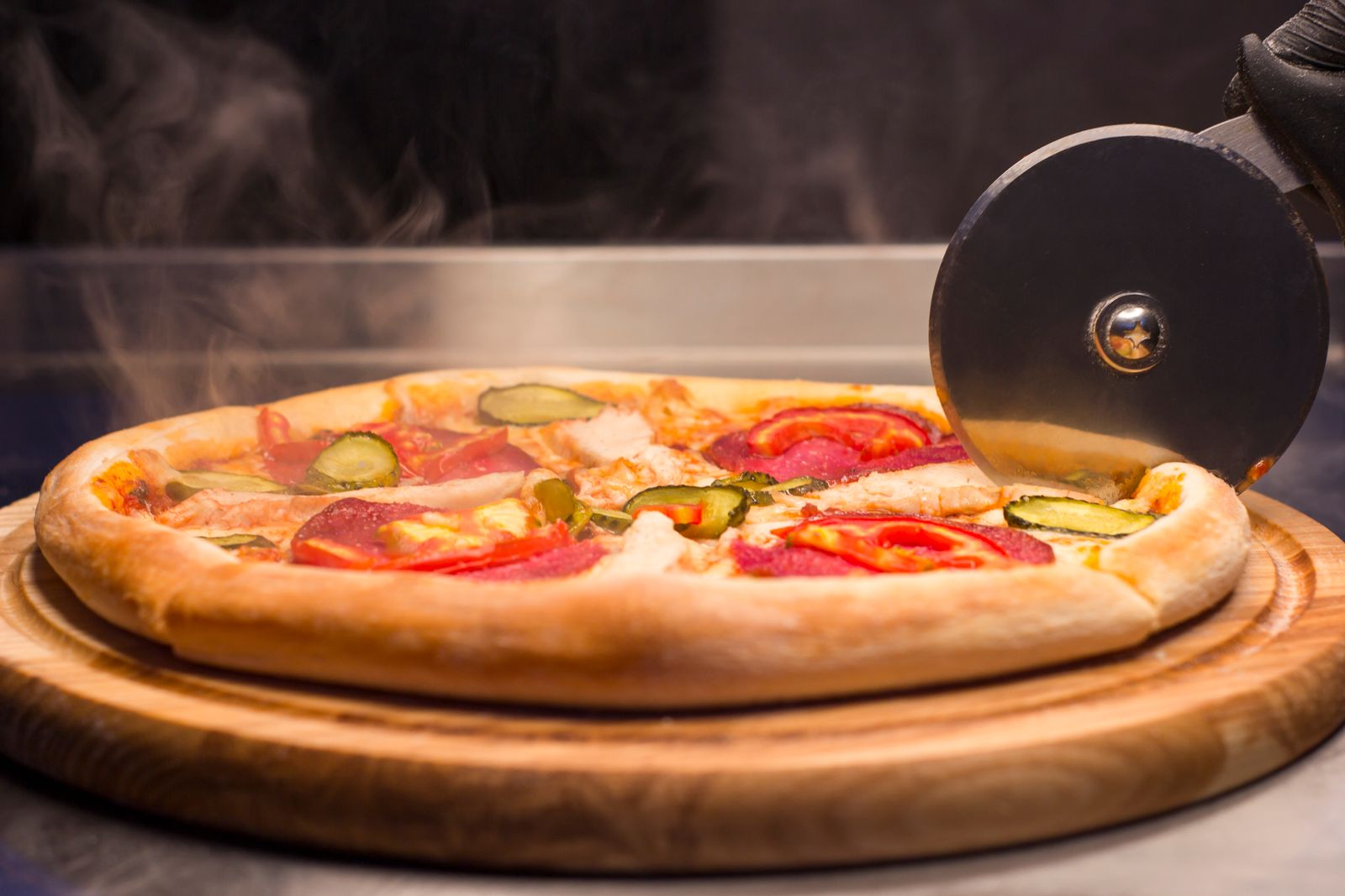 Detailní záběr čerstvě upečené pizzy s párou stoupající z horkého těsta