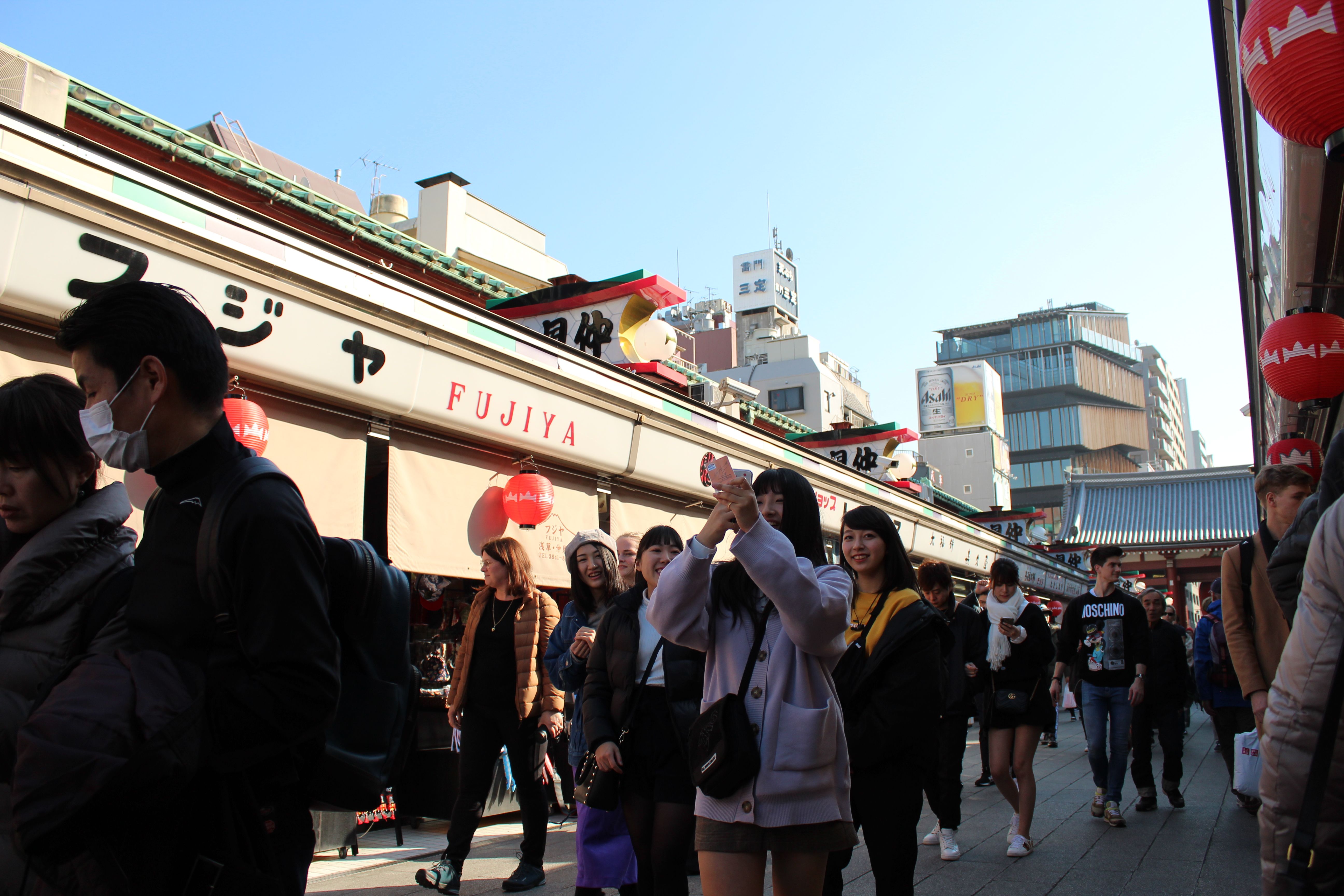 Bustling street in Tokyo with people and shops, capturing vibrant urban life.