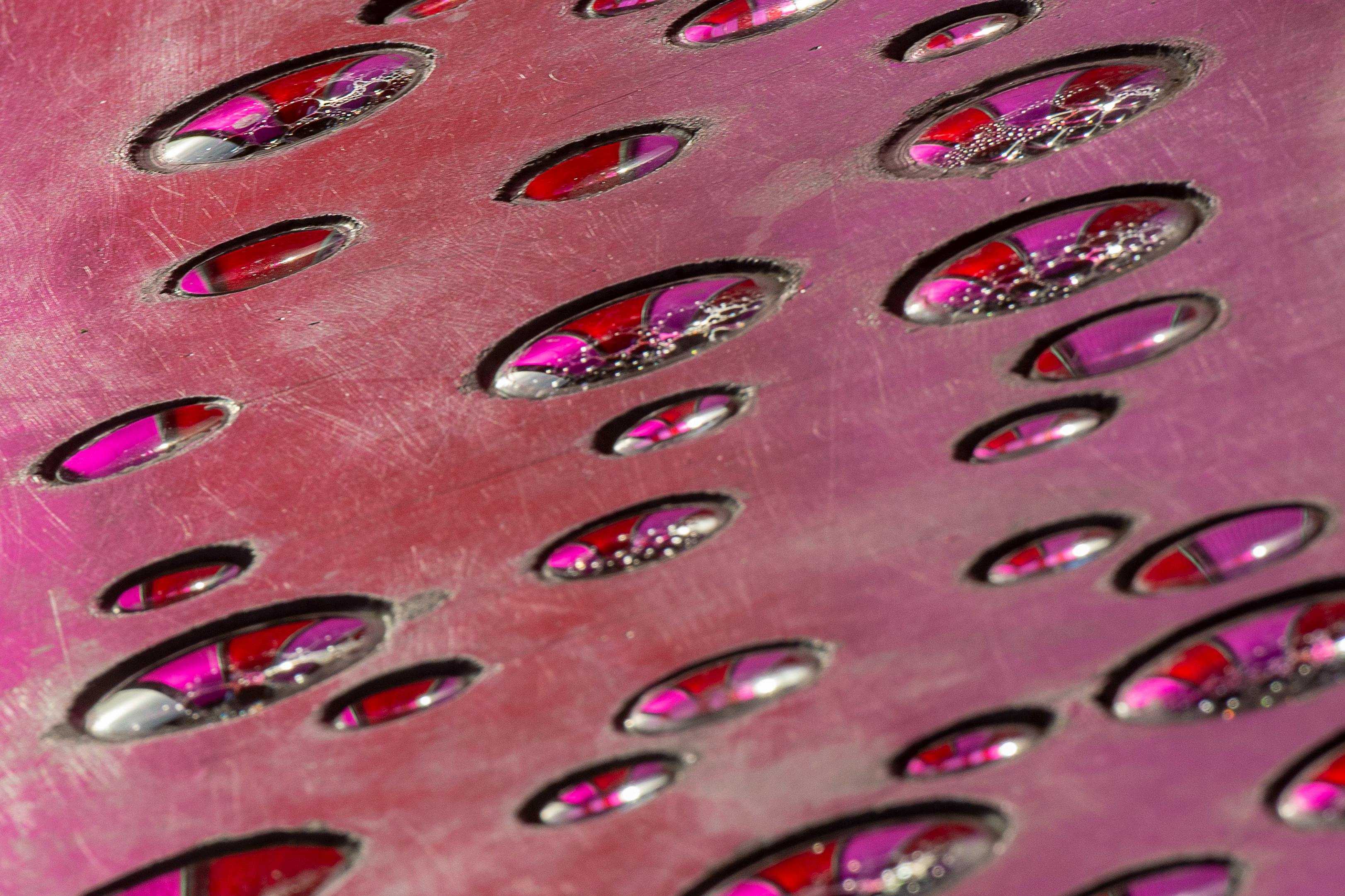 Gratis Primo piano artistico di una superficie metallica con riflessi di luce rosa, che creano un disegno astratto. Foto a disposizione