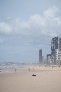 Explore the bustling beach and iconic skyline of Surfers Paradise, Queensland, Australia, on a sunny day.