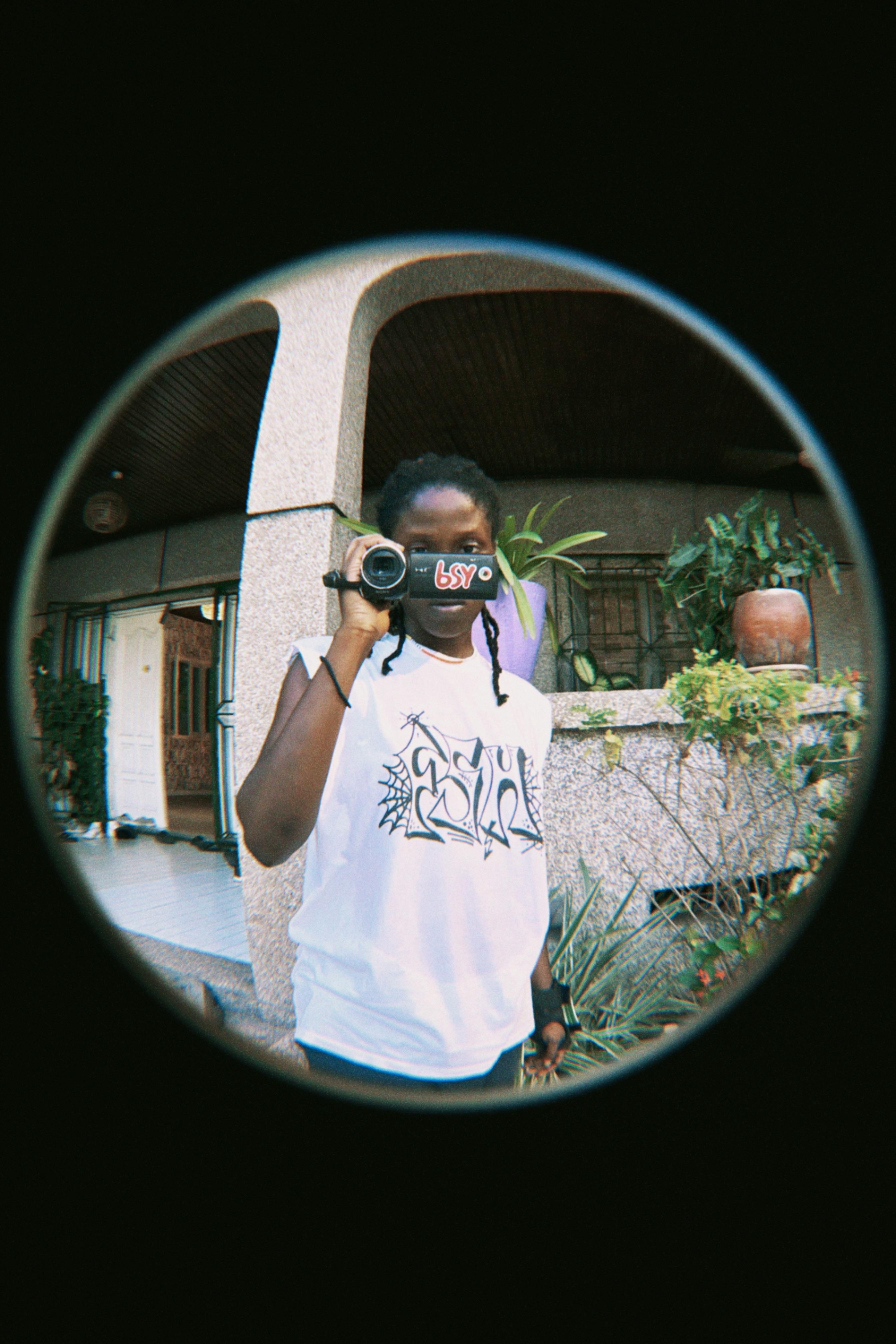 A person uses a camera in an outdoor setting, capturing a creative moment.