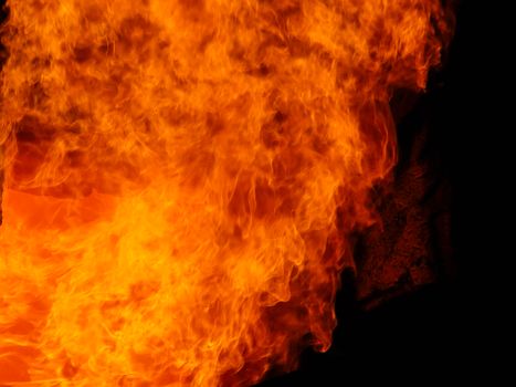 Vivid flames dance against a dark background, creating dramatic contrasts.