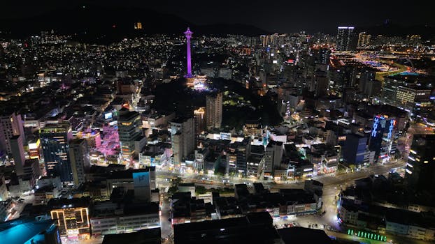 Stunning aerial night view of Busan city, highlighting Busan Tower in South Korea.