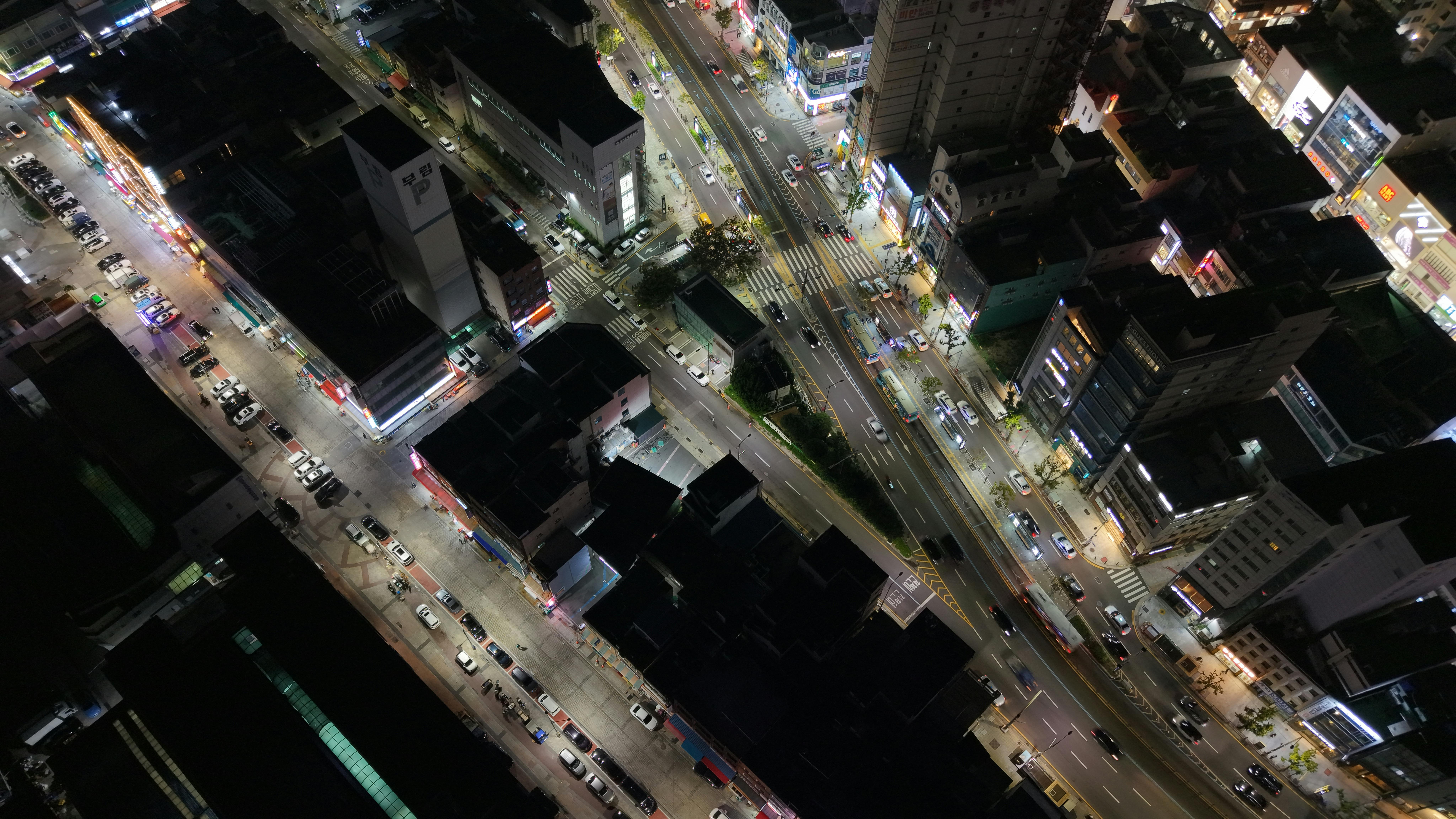 A dynamic aerial view of Busan's city streets at night, showcasing bustling urban life.