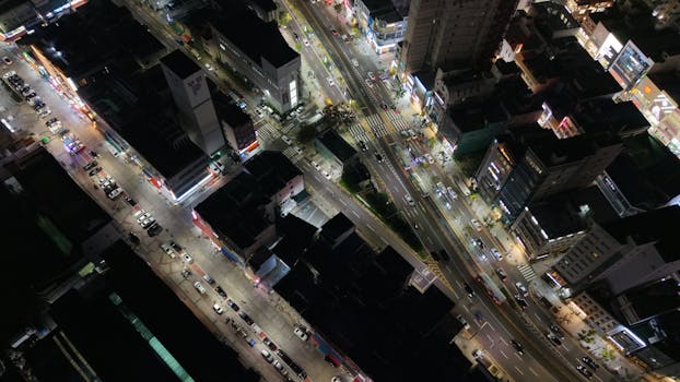 A dynamic aerial view of Busan's city streets at night, showcasing bustling urban life.