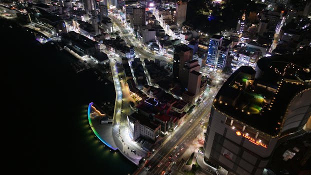 Stunning aerial shot of Busan cityscape at night with illuminated streets and buildings.