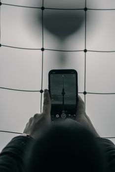 A smartphone capturing a clock against a modern grid background.