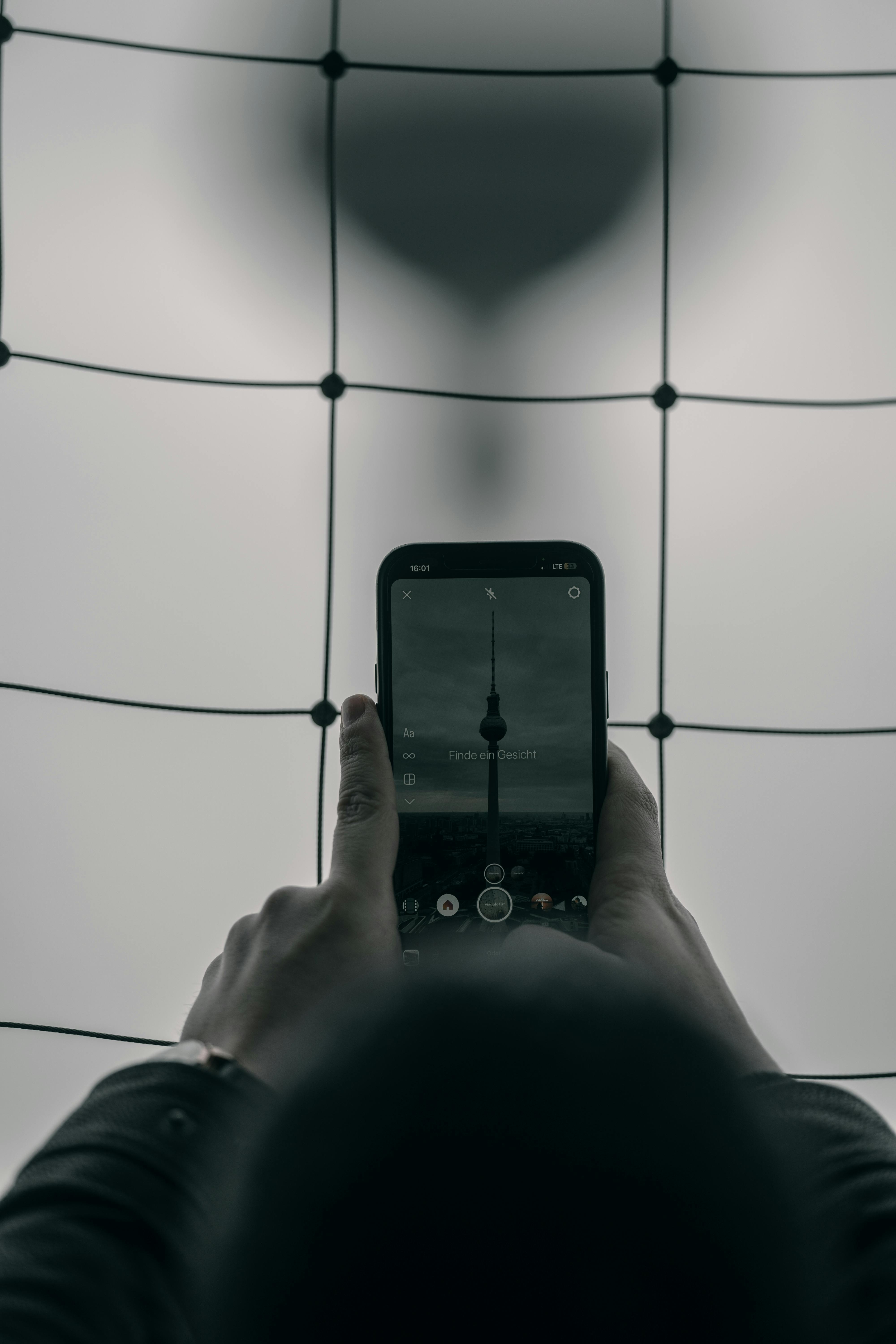 Gratis Uno smartphone che immortala un orologio su uno sfondo a griglia moderna. Foto a disposizione