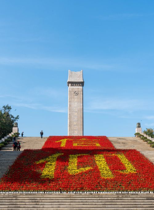 Free A significant monument with a floral display of Chinese characters under a clear blue sky. Stock Photo