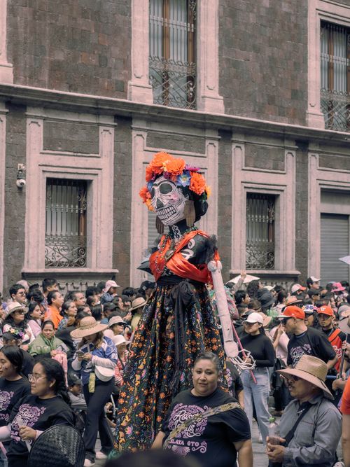 Free Vibrant Day of the Dead celebration in Mexico City with colorful skeletons and cultural festivity. Stock Photo