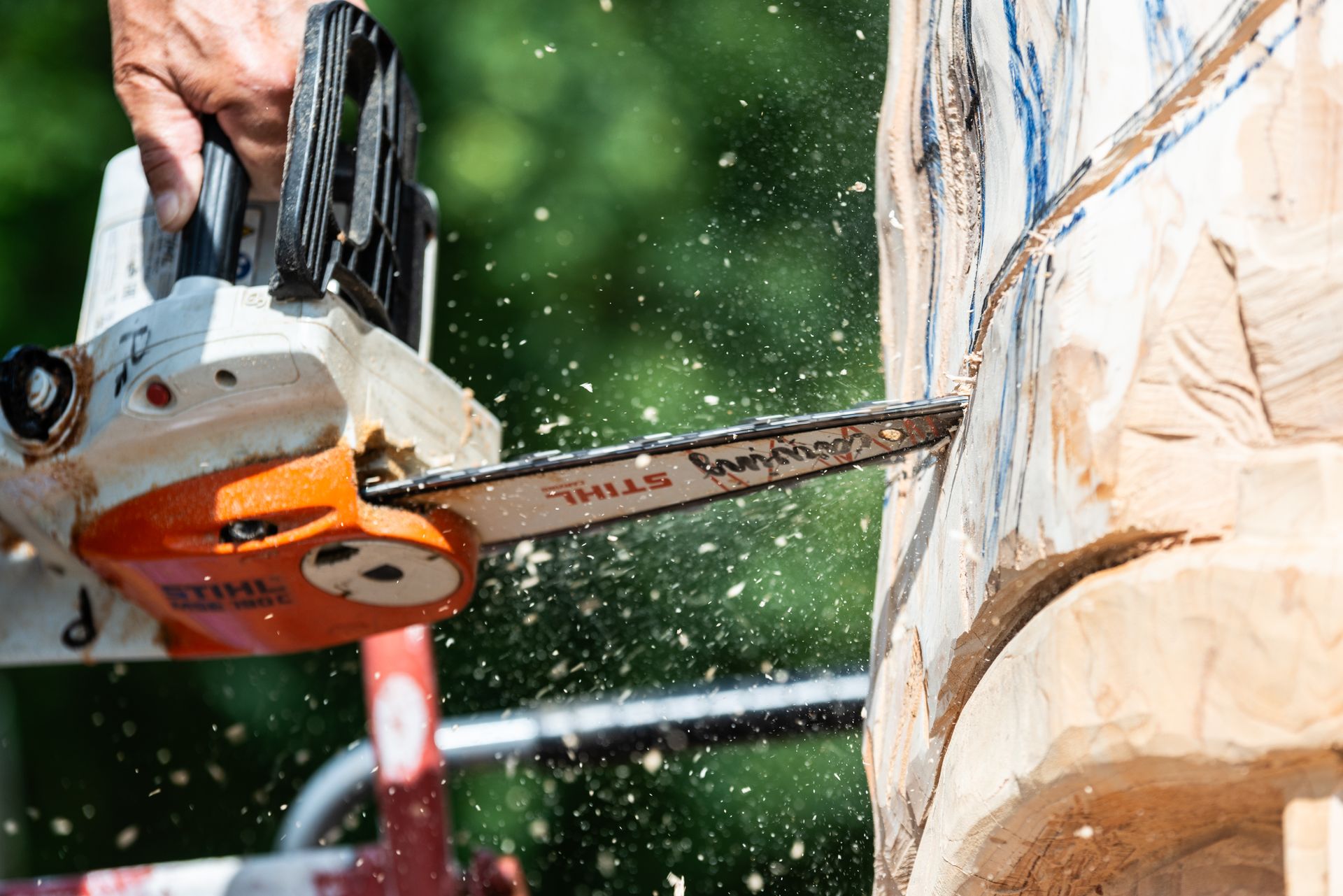 Close-up of chainsaw carving wood sculpture, showcasing power and precision.