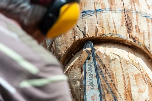 Free Artist carving intricate wooden sculpture with chainsaw, focused on details. Stock Photo