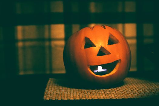 A carved pumpkin glowing with a candle inside, perfect for Halloween ambiance.