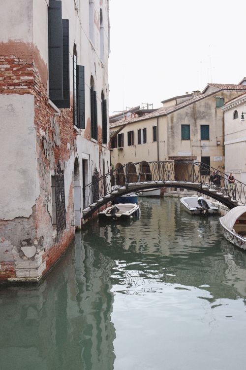 Free Scenic view of a narrow canal in Venice with boats and historic architecture. Stock Photo