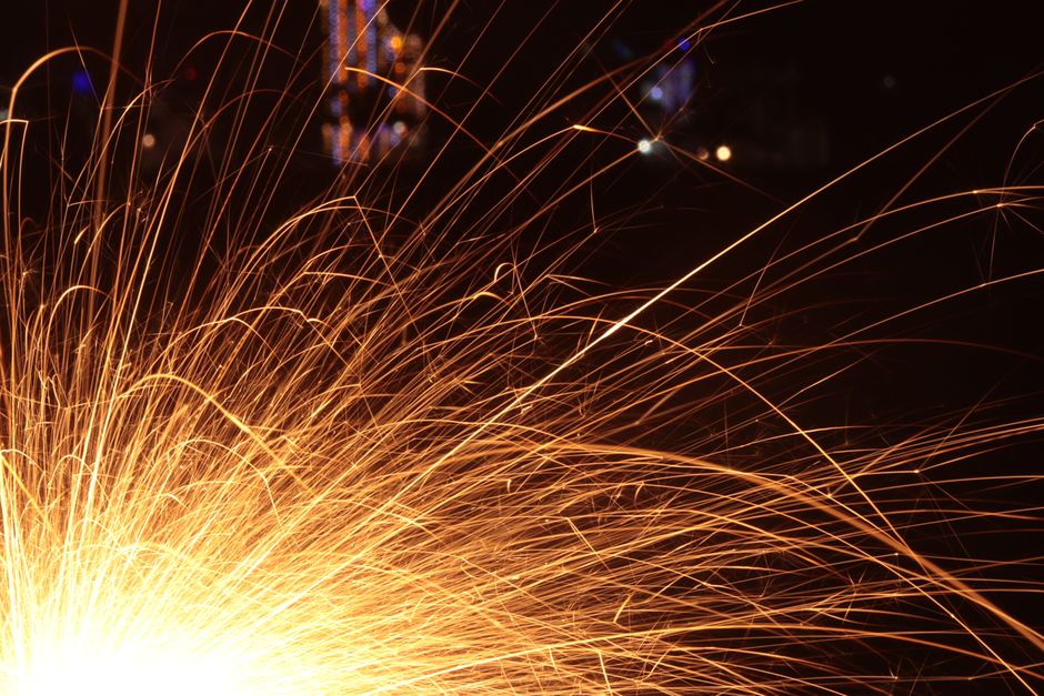 Bright sparks illuminate the dark night, creating a dynamic and vivid scene.