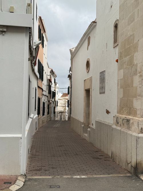 Free Idyllic narrow street in a European village with traditional white stone buildings. Stock Photo
