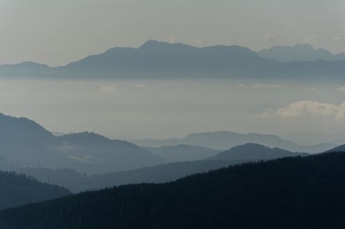 Free Serene mountain landscape with layers of mist and cloudy sky. Stock Photo