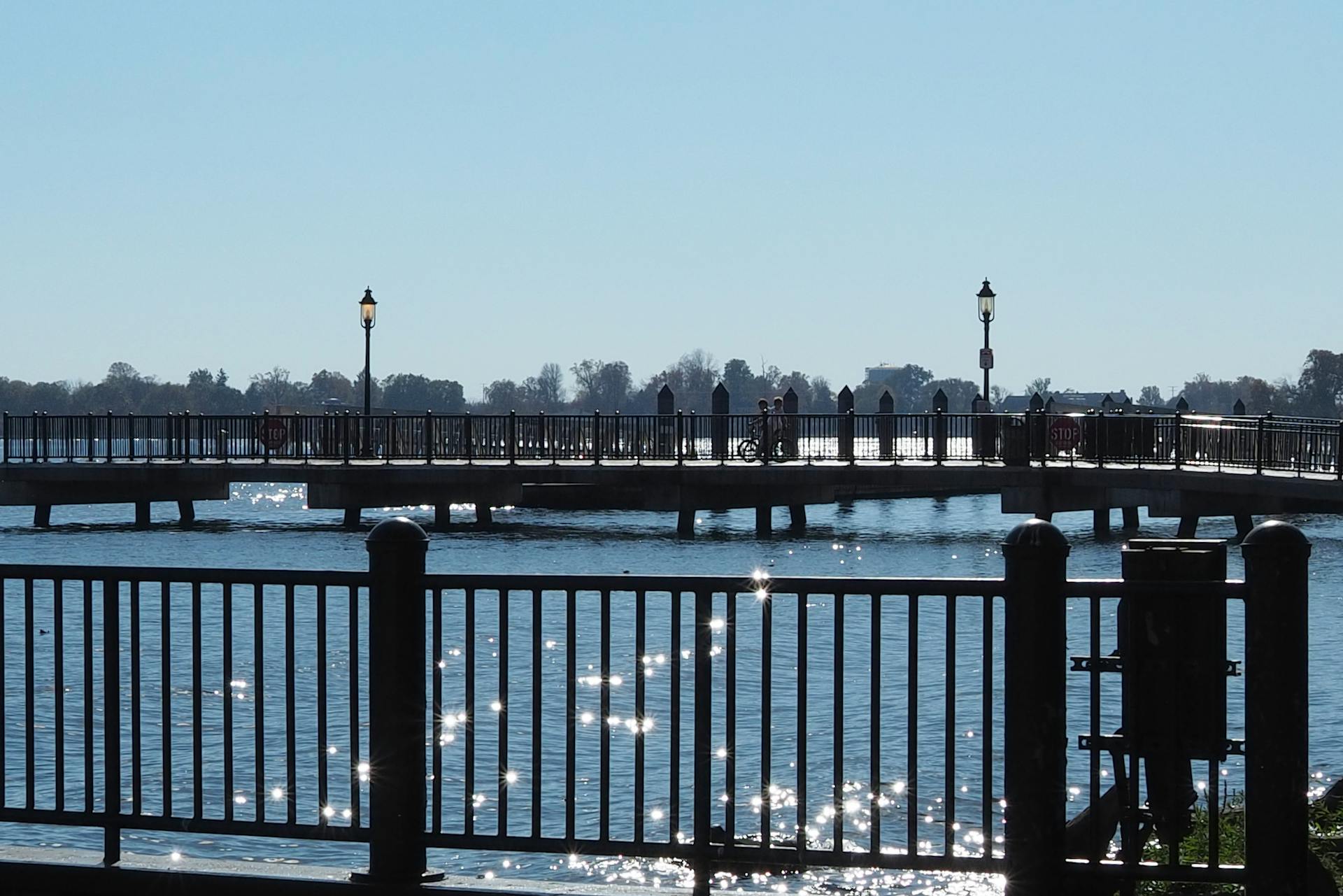 View of a bridge over the Delaware River in Bristol, Pennsylvania with sunlight reflections on the water.