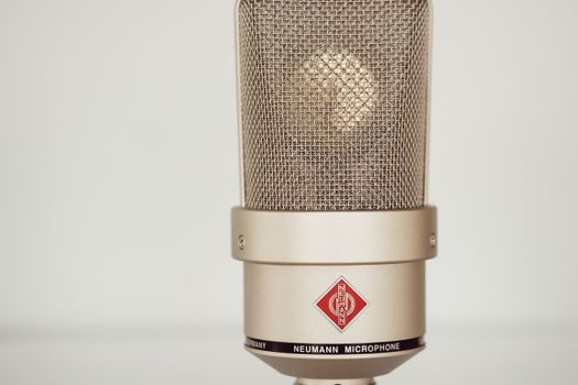 Close-up image of a vintage Neumann condenser microphone showcasing its metallic design.
