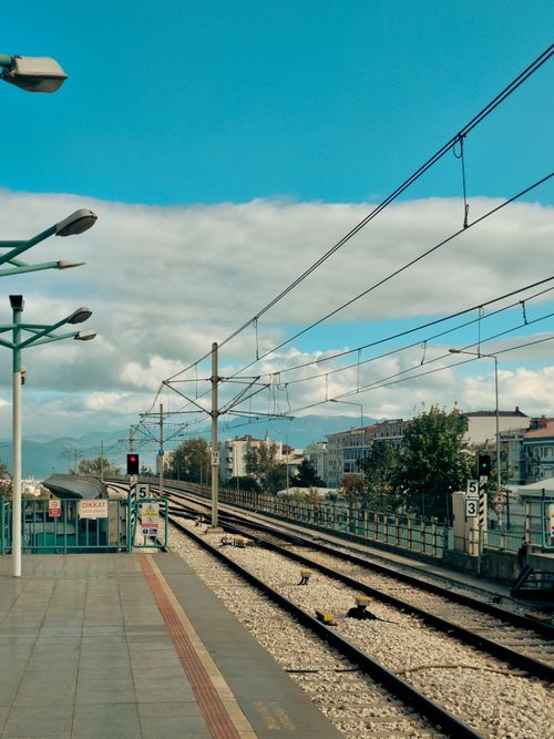 Free A clear view of an empty urban train station under a bright blue sky, ideal for travel themes. Stock Photo