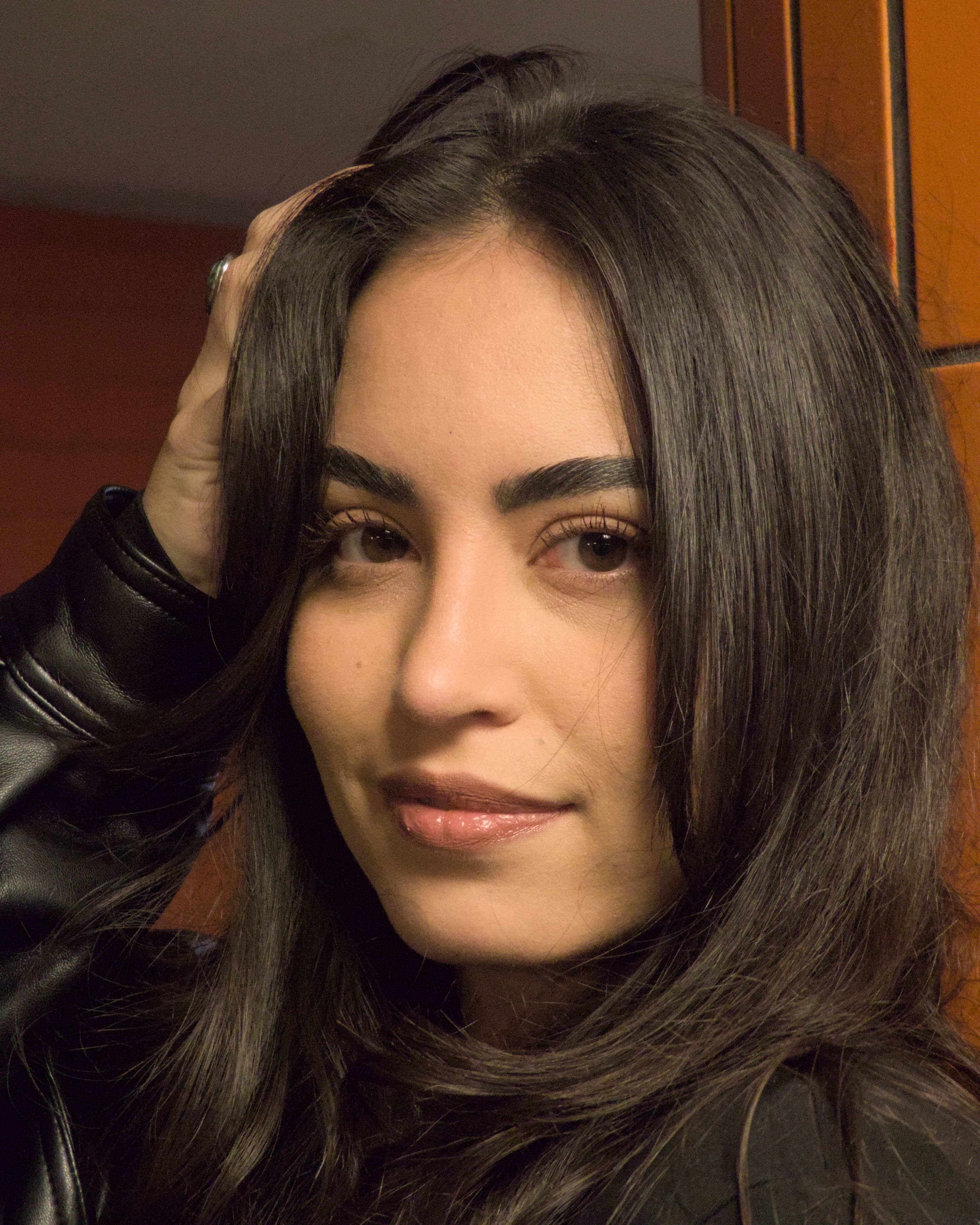 Close-up portrait of a woman with long hair in Berlin, showcasing a confident expression.