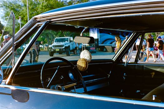 Interior of a classic car parked outdoors, showcasing vintage design elements and event atmosphere.