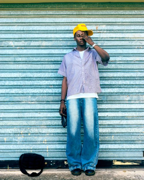 Free Young adult in casual street style against a metal shutter. Stock Photo