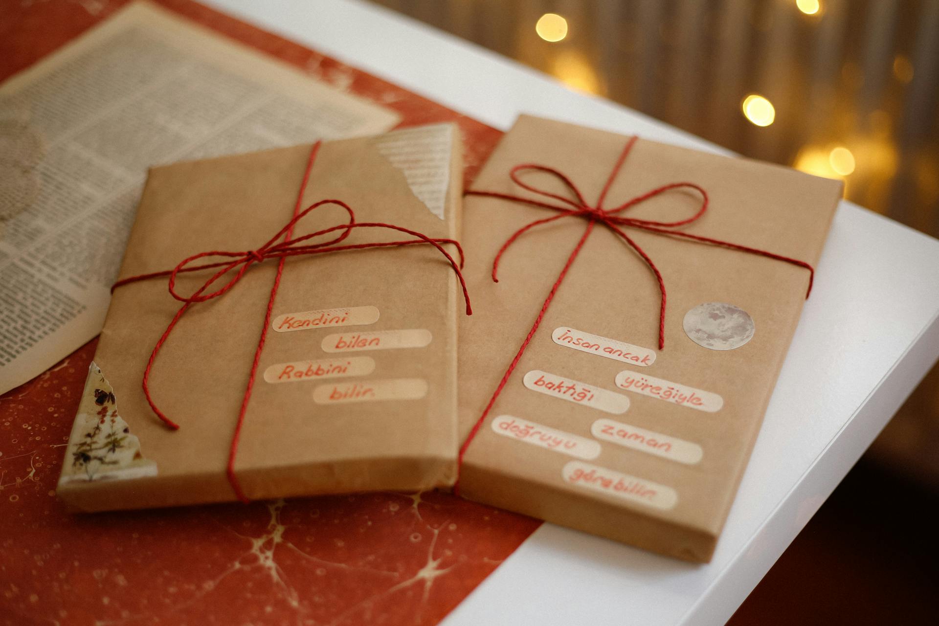 Cozy vintage scene featuring two books wrapped in paper with red string, set on a warm-toned table.