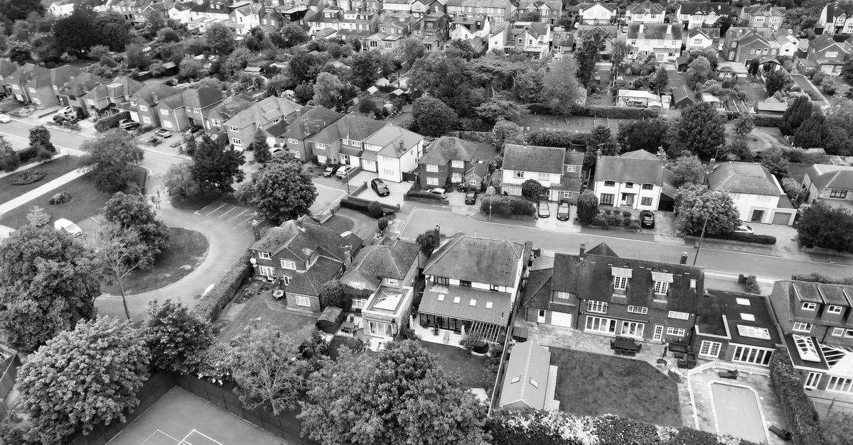 Black and white aerial view of a suburban neighborhood in Chelmsford, England, featuring houses and greenery.