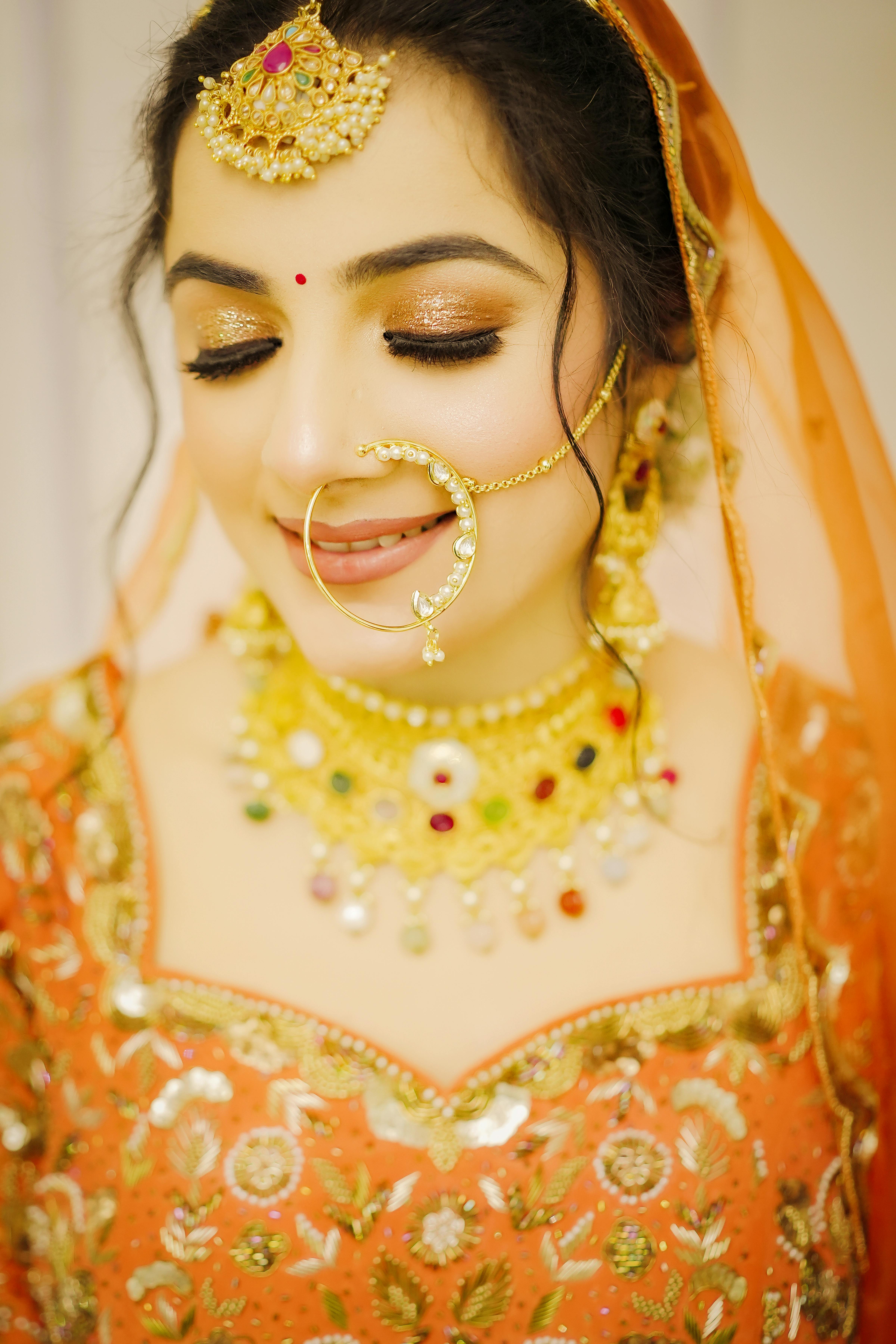 Close-up of an Indian bride in ornate traditional wedding attire with golden jewelry.