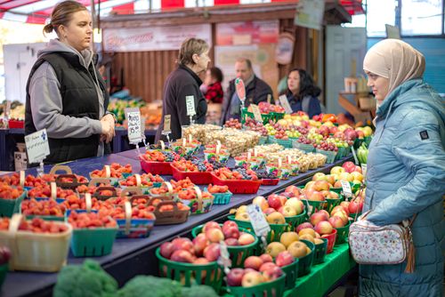 Free Colorful farmers market showcasing fresh produce and diverse shoppers interacting. Stock Photo
