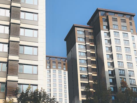 Contemporary high-rise residential buildings against a clear blue sky in Tianjin, China.