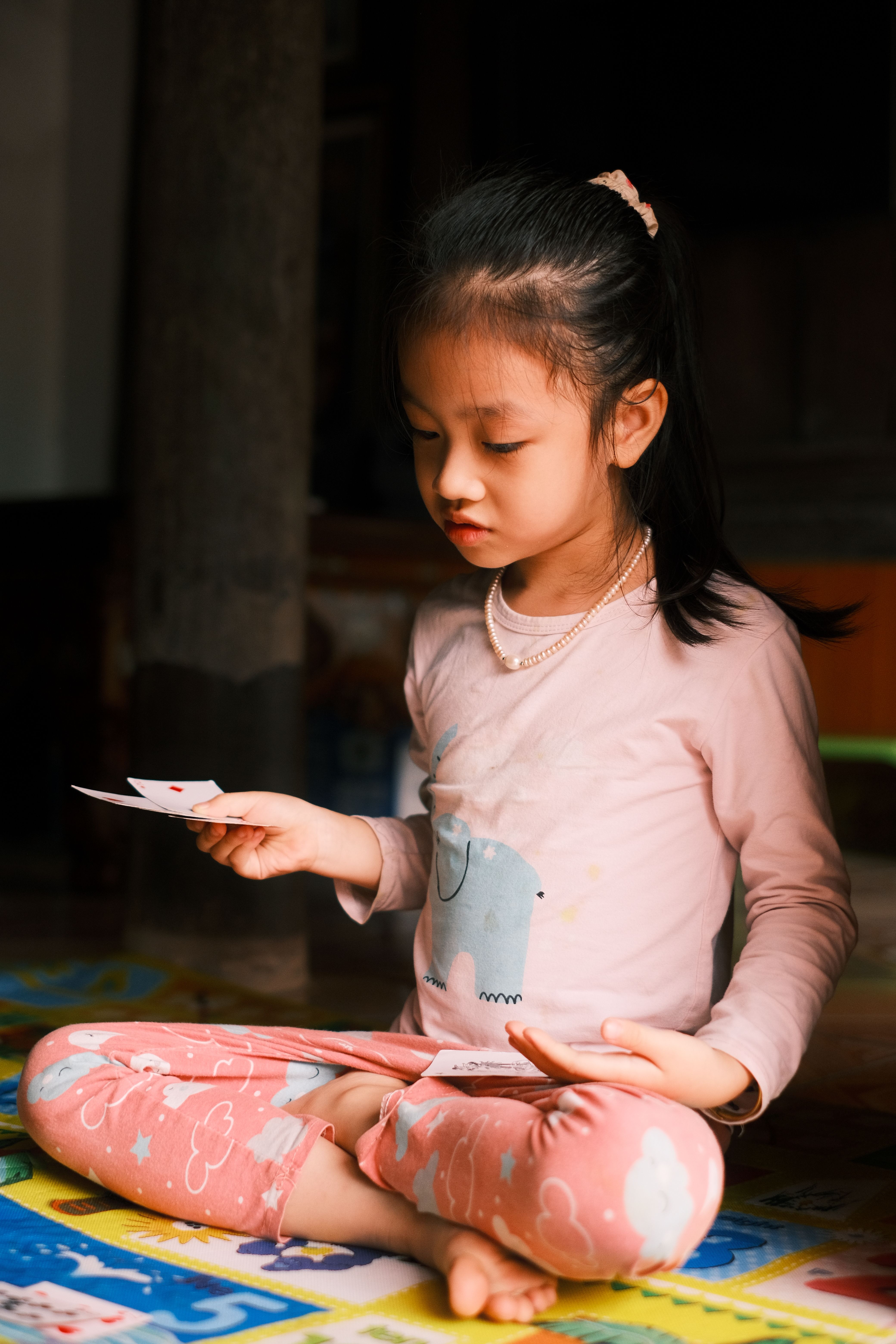 Child Engaged In Card Game Indoors Free Stock Photo