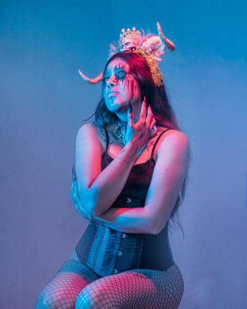 Free Captivating portrait of a woman with unique makeup and headpiece in vivid lighting. Stock Photo