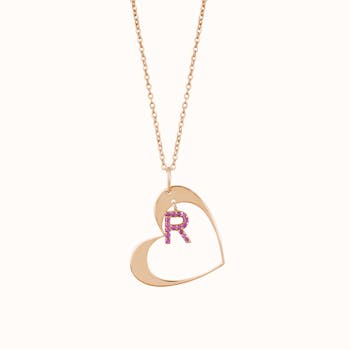 A stylish gold heart necklace with a gemstone initial R, perfect for personalized fashion jewelry.