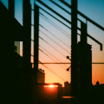 Silhouette of urban buildings at sunset with geometric lines creating a dramatic view.
