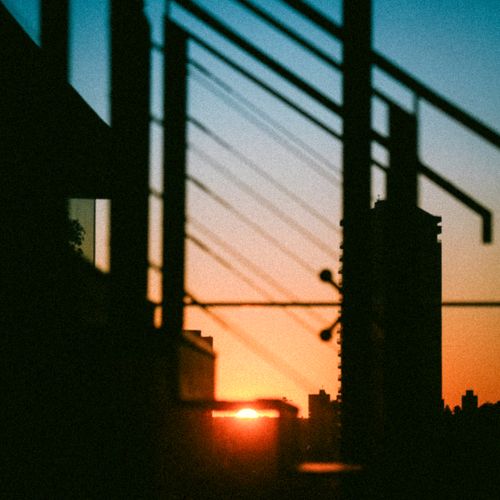 Free Silhouette of urban buildings at sunset with geometric lines creating a dramatic view. Stock Photo